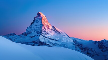 Snow-covered mountain peak illuminated by the sunrise, showcasing a stunning natural landscape with vibrant colors in a serene winter scene.