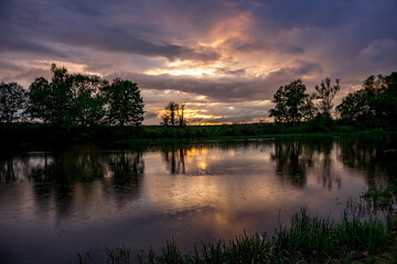 Rain over the river during the sunset in May evening