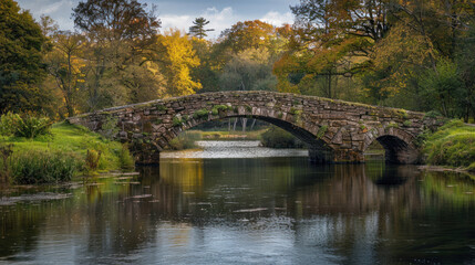Fototapeta premium Historic stone bridge crossing a tranquil river in a scenic area