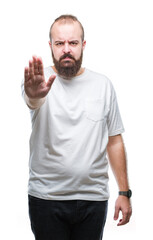 Young caucasian hipster man wearing casual t-shirt over isolated background doing stop sing with palm of the hand. Warning expression with negative and serious gesture on the face.