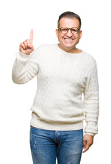 Middle age arab man wearing glasses over isolated background showing and pointing up with finger number one while smiling confident and happy.