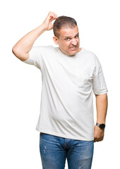 Fototapeta premium Middle age arab man wearig white t-shirt over isolated background confuse and wonder about question. Uncertain with doubt, thinking with hand on head. Pensive concept.