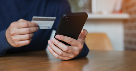 close up man hand holding smartphone with credit card for pay online shopping e-commerce concept