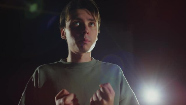 Tilt up shot of talented actor performing expressive monologue on stage while playing in theatre or having rehearsal