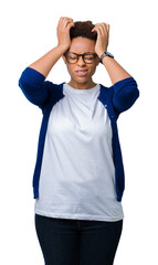 Fototapeta premium Young beautiful african american woman wearing glasses over isolated background suffering from headache desperate and stressed because pain and migraine. Hands on head.