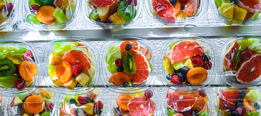Boxes with pre-packaged fruit salads in a commercial fridge