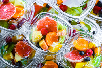 Boxes with pre-packaged fruit salads in a commercial fridge