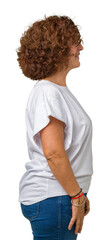 Fototapeta premium Beautiful middle ager senior woman wearing white t-shirt over isolated background looking to side, relax profile pose with natural face with confident smile.