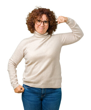 Beautiful middle ager senior woman wearing turtleneck sweater and glasses over isolated background Strong person showing arm muscle, confident and proud of power