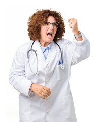 Middle ager senior doctor woman over isolated background angry and mad raising fist frustrated and furious while shouting with anger. Rage and aggressive concept.