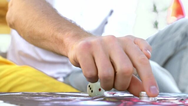 Man Playing Ancient Indian Board Game Leela, Man Rolls Dice and Makes Move with Chip, Hands Close-up.