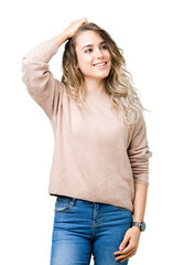Fototapeta premium Beautiful young blonde woman wearing sweatershirt over isolated background Smiling confident touching hair with hand up gesture, posing attractive