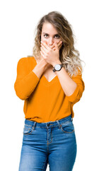 Beautiful young blonde woman over isolated background shocked covering mouth with hands for mistake. Secret concept.