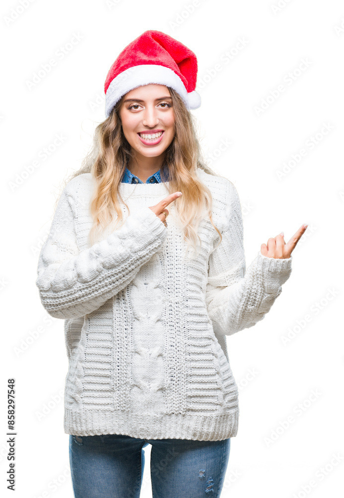 Sticker beautiful young blonde woman wearing christmas hat over isolated background smiling and looking at t