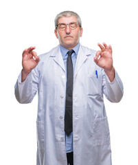 Handsome senior doctor, scientist professional man wearing white coat over isolated background relax and smiling with eyes closed doing meditation gesture with fingers. Yoga concept.