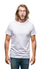 Young handsome man with long hair wearing glasses over isolated background afraid and shocked with surprise expression, fear and excited face.