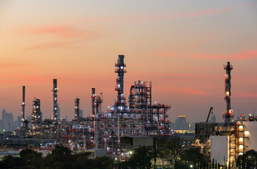 Oil refinery plant industry and port, Aerial view oil and gas petrochemical industrial, Refinery factory oil storage tank and pipeline steel at night, Ecosystem and healthy environment concepts.