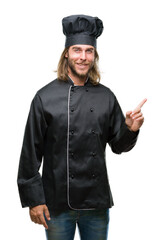 Young handsome cook man with long hair over isolated background with a big smile on face, pointing with hand and finger to the side looking at the camera.