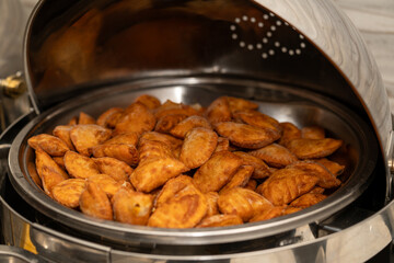 Mini vegan Empanadas at an event in a metal warmer. Very spicy and crunchy food.