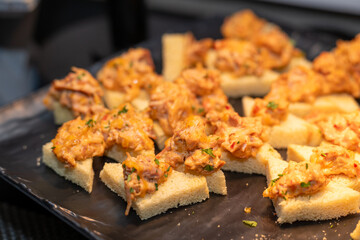 Chicken bread bite appetizer. Shredded spicy chicken on crunch bread triangles