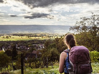 A girl with a backpack looking at the sunset in a forest in Hungary, Upper Balaton