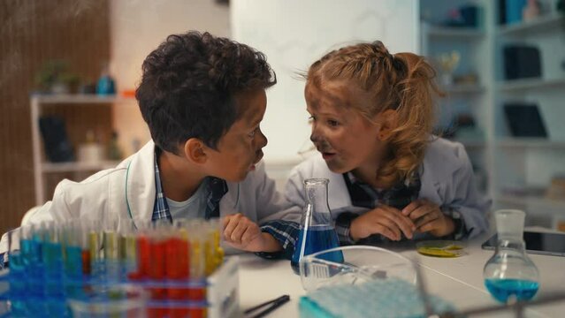 Funny schoolchildren look into flask, explosion and smoke during lab experiment