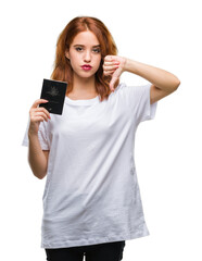 Fototapeta premium Young beautiful woman holding passport of australia over isolated background with angry face, negative sign showing dislike with thumbs down, rejection concept