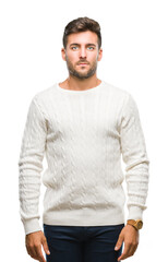 Fototapeta premium Young handsome man wearing winter sweater over isolated background with serious expression on face. Simple and natural looking at the camera.