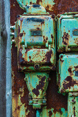 Rusted Green Electrical Boxes on a Weathered Wall