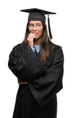 Young hispanic woman wearing graduated cap and uniform looking stressed and nervous with hands on mouth biting nails. Anxiety problem.
