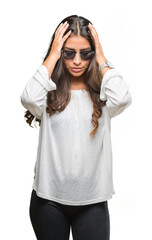 Young beautiful arab woman wearing sunglasses over isolated background suffering from headache desperate and stressed because pain and migraine. Hands on head.