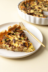Portion of pie on a plate, homemade quiche with seasonal forest mushrooms Chanterelles on a yellow background