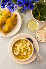 Stewed rabbit with rice, broccoli and rice cakes, a served table with food and a vase of flowers, a delicious hearty lunch or dinner