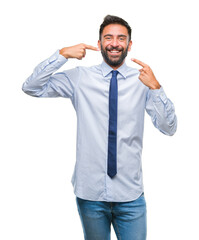 Adult hispanic business man over isolated background smiling confident showing and pointing with fingers teeth and mouth. Health concept.