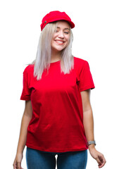 Young blonde woman wearing red hat over isolated background looking away to side with smile on face, natural expression. Laughing confident.