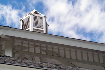 Close up of top two tiers of gazebo with white clouds and blue sky and a glimpse at the inside...