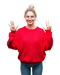 Young beautiful blonde woman wearing red sweater and glasses over isolated background showing and pointing up with fingers number eight while smiling confident and happy.