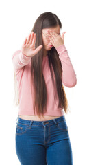 Young Chinese woman over isolated background wearing glasses covering eyes with hands and doing stop gesture with sad and fear expression. Embarrassed and negative concept.