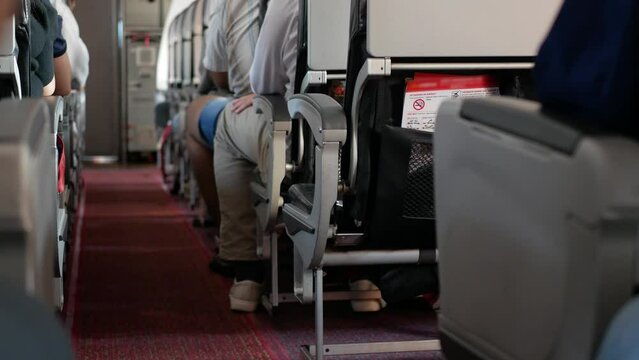 view inside airplane aircraft through aisle pathway on the plane to safety card in pocket on back of seat inside aircraft