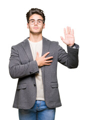 Young business man wearing glasses over isolated background Swearing with hand on chest and open...