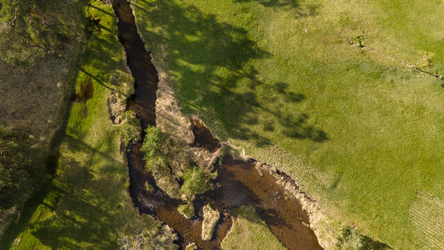 Drone aerial top view of mountain river and forest at sunset. Aerial view, meandering river landscape at Zlatibor, Serbia.