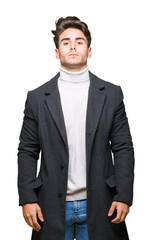 Young elegant man wearing winter coat over isolated background Relaxed with serious expression on face. Simple and natural looking at the camera.