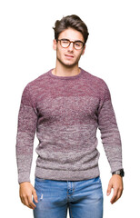 Young handsome man wearing glasses over isolated background winking looking at the camera with sexy...