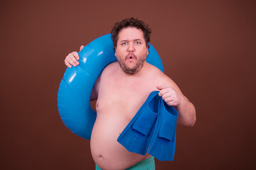 Dreams about the weekend. Funny fat man enjoys his vacation at the sea. Brown background.