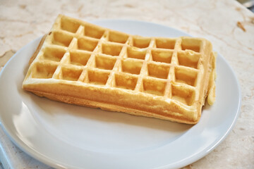 Freshly baked waffles on a white plate. Close-up