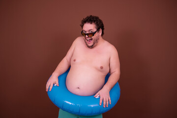 Dreams about the weekend. Funny fat man enjoys his vacation at the sea. Brown background.