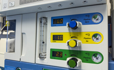 modern hospital anesthesia machine with airway ventilation system, featuring digital screens and various tubes, set in a clean and well-lit surgical room, ready for patient care