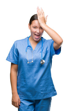 Young caucasian doctor woman wearing medical uniform over isolated background surprised with hand on head for mistake, remember error. Forgot, bad memory concept.