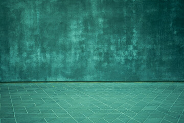 Interesting texture of a green concrete wall with a floor with geometric figures in the form of triangles and diamonds
