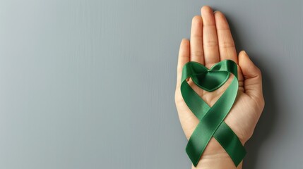 Template featuring a hand holding a green ribbon with a heart, isolated on a grey background, promoting organ donation